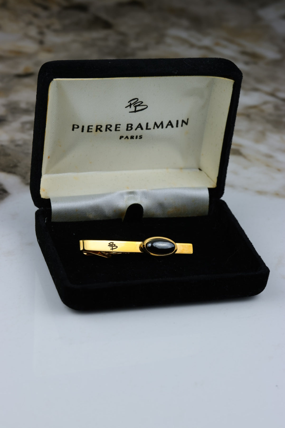 Pierre Balmain – spinka do krawata pozłacana z okrągłym czarnym wypełnieniem i logo (S46)