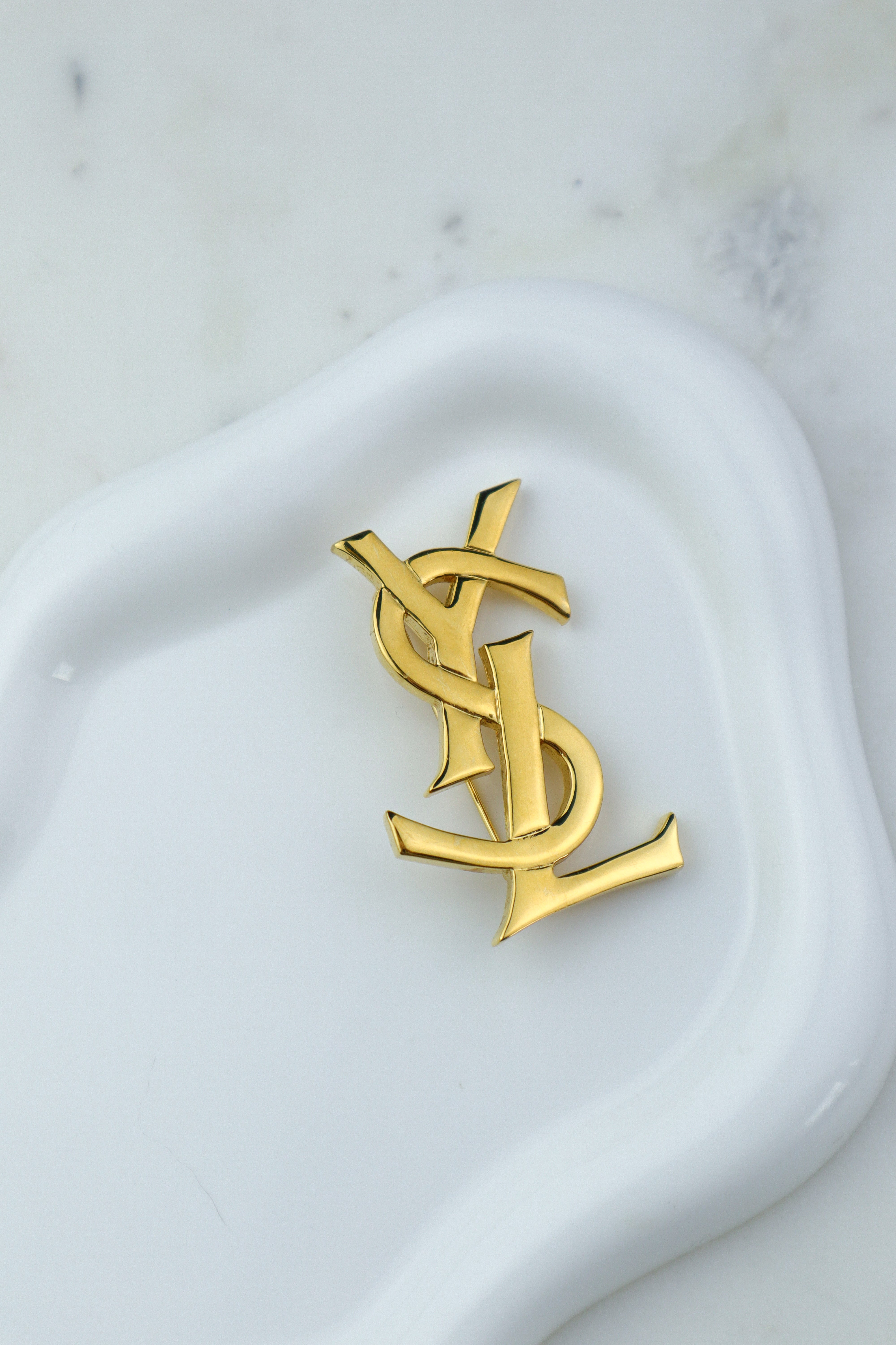 Yves Saint Laurent - broszka monogram Cassandre