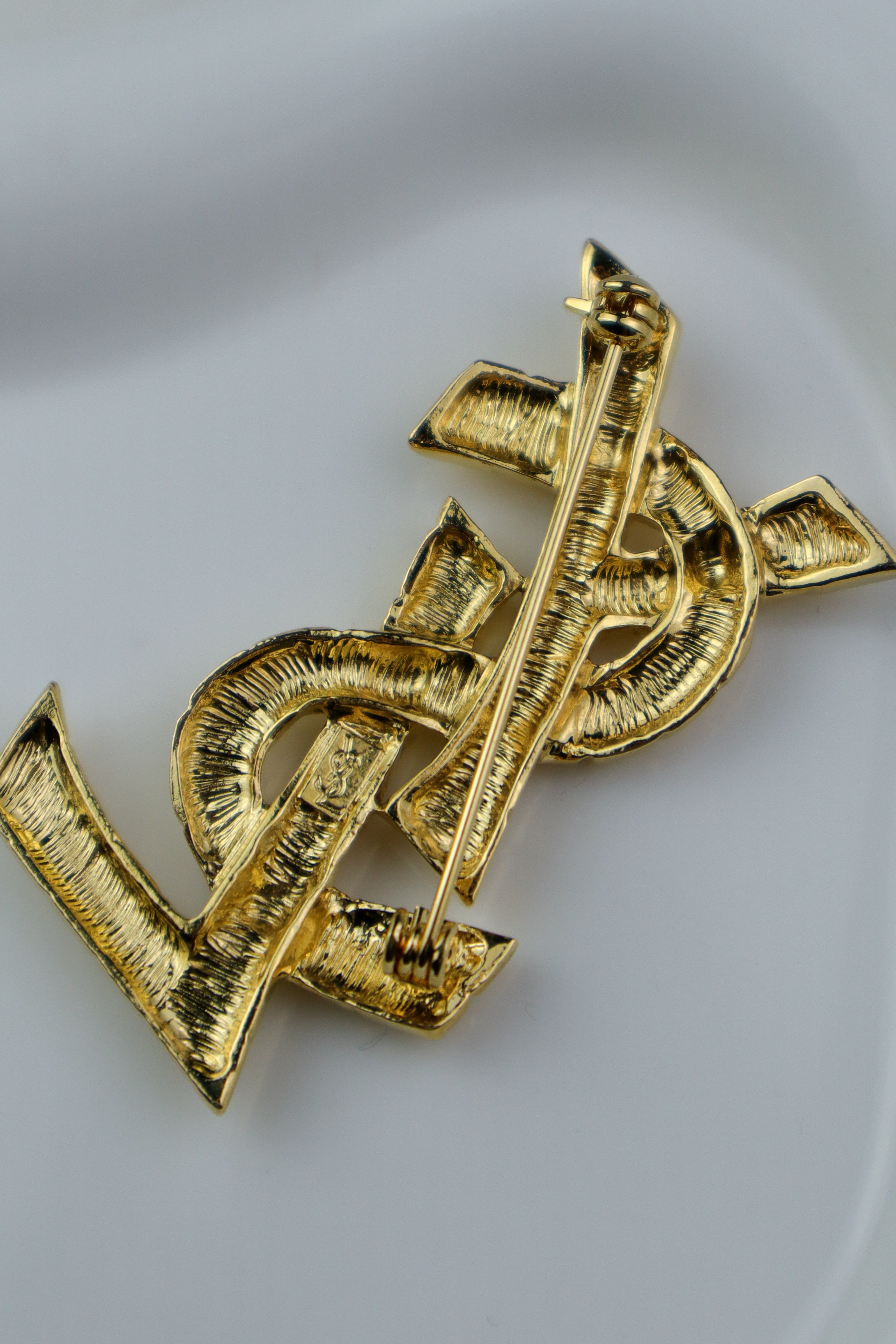 Yves Saint Laurent - broszka monogram o młotkowanej strukturze