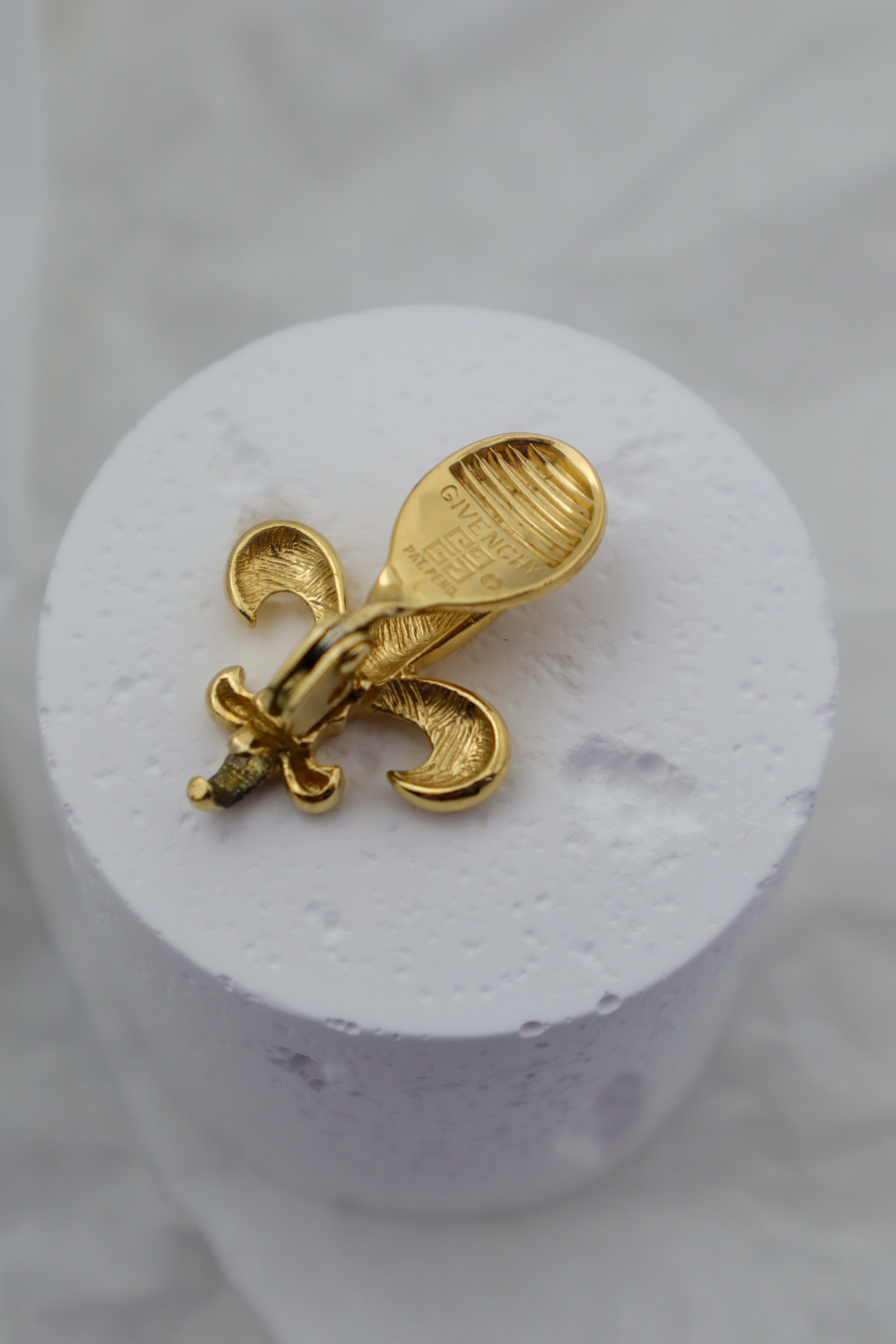 Givenchy - złocone klipsy z motywem fleur‑de‑lis