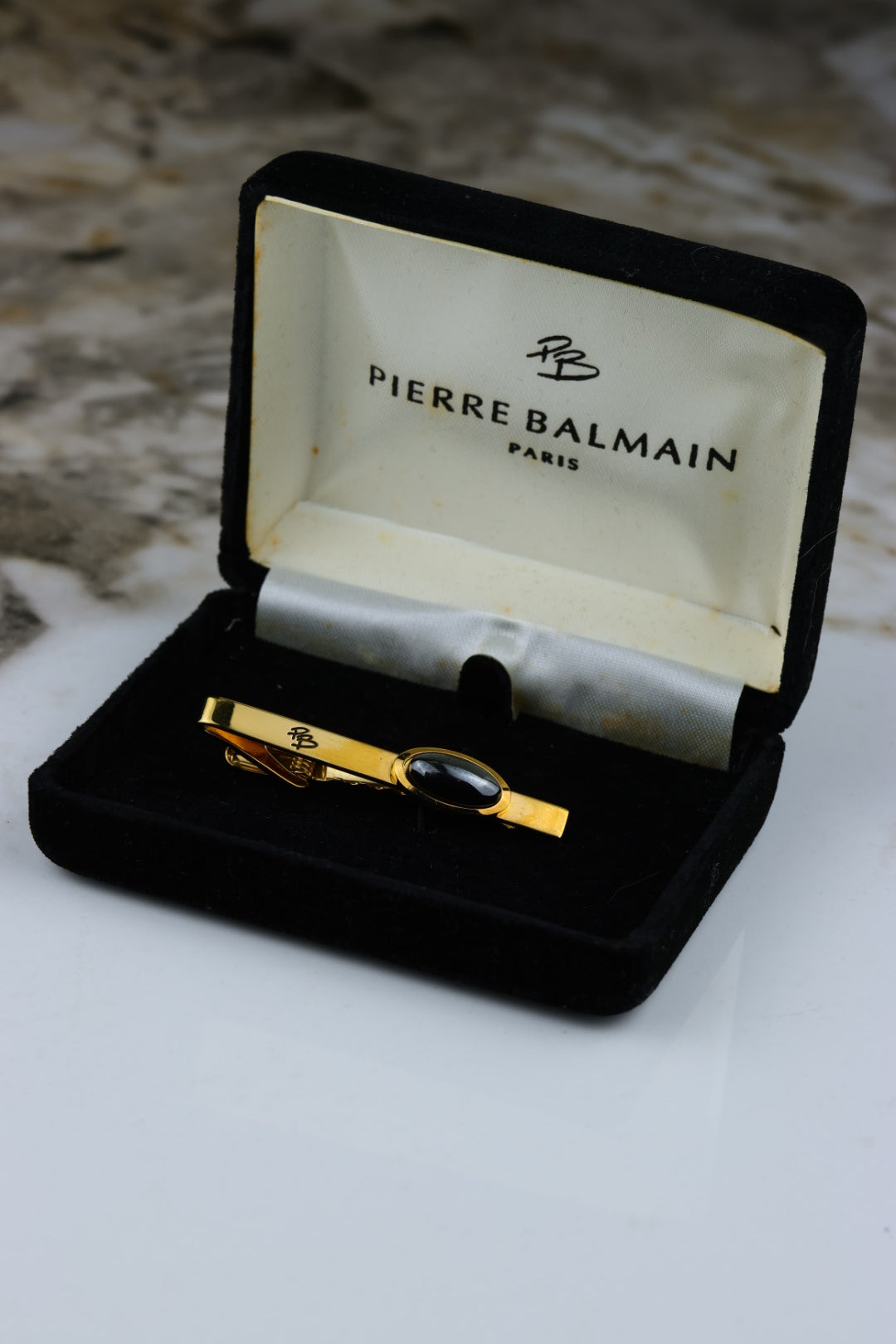 Pierre Balmain – spinka do krawata pozłacana z okrągłym czarnym wypełnieniem i logo (S46)